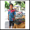 Remi, muy contento ayuda a su familia en el puesto de artesan&iacute;a.