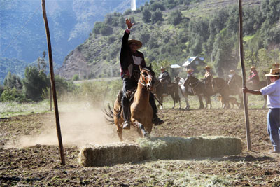 Juego tradicional, alcanzar la botella en un salto del caballo.