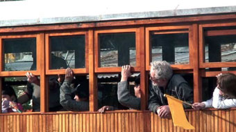 Pasajeros emocionados asomados a las ventanas del carro.