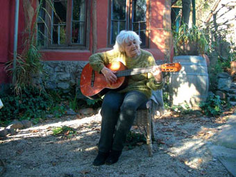 Doña Pita Barrios, cantando y tocando su guitarra en su casa de San José