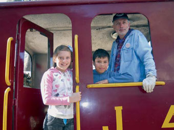 Alan y su prima celebran arriba de la locomotora, junto al maquinista Derek